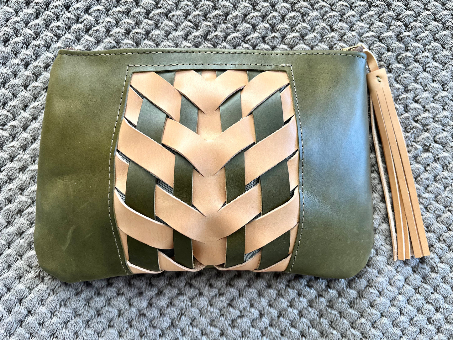Green and cream woven clutch has matching cream tassel.