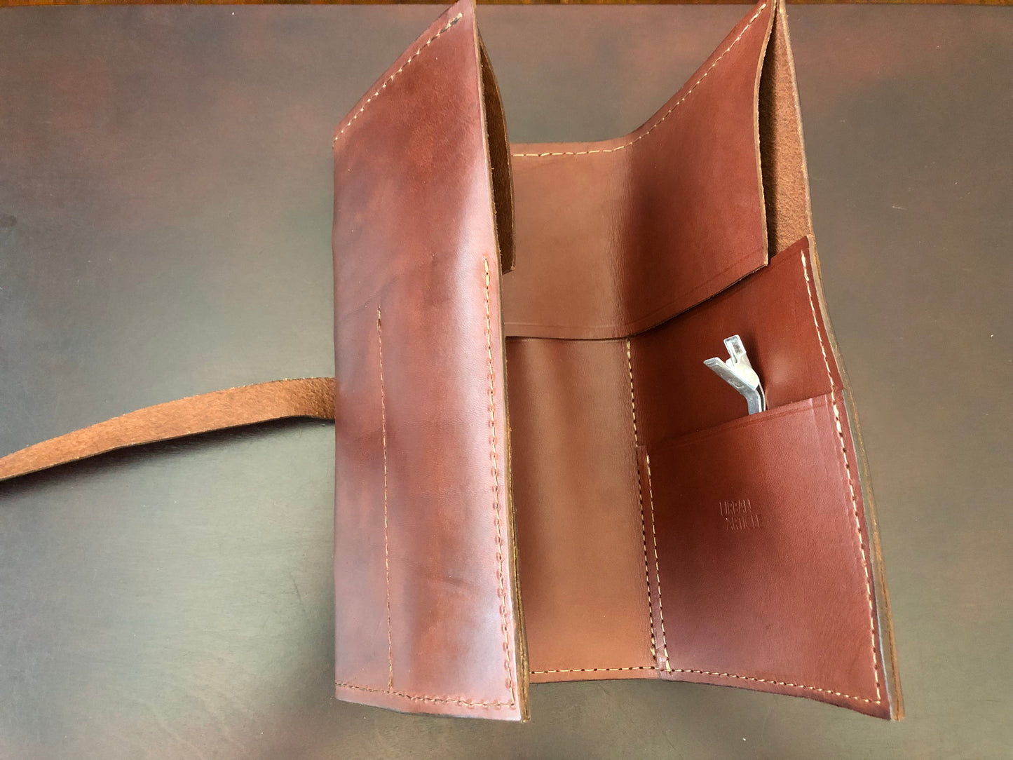 Leather tool roll shown open with tools.