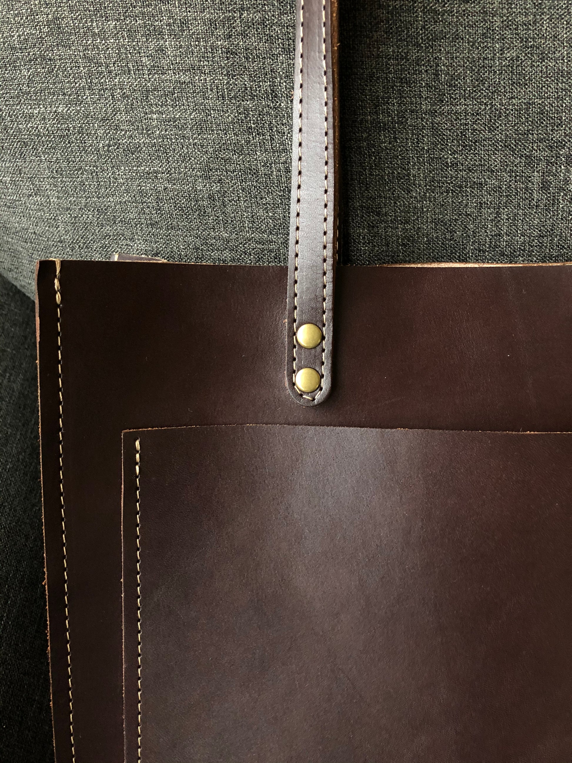 Close up of luxe details. Stiched straps and brass rivets.