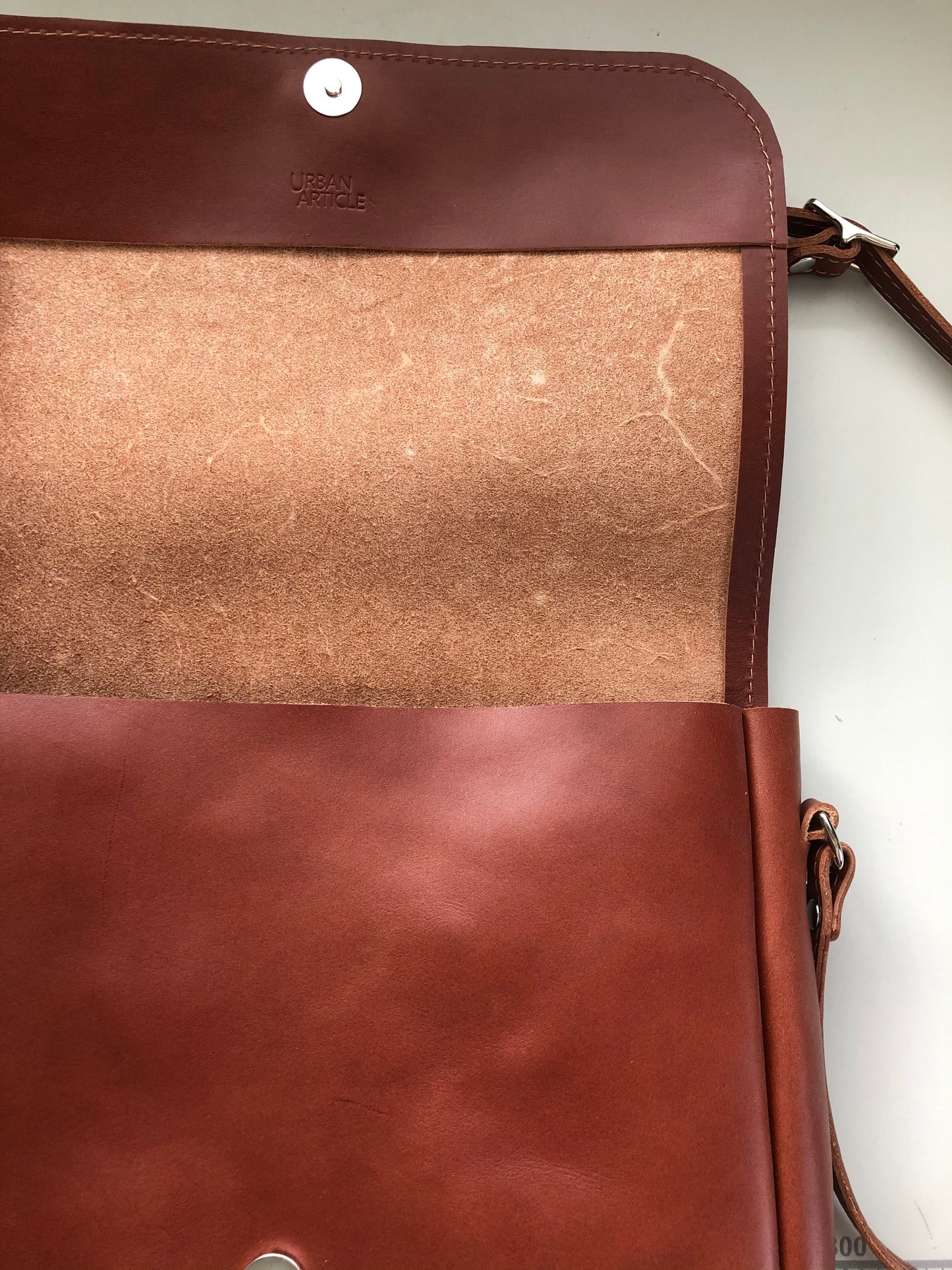 View of interior of rich brown leather bag.