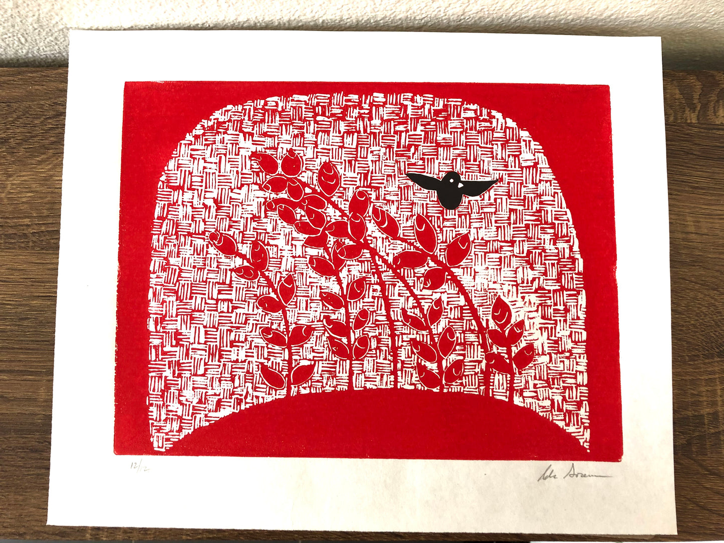 Cherry red lino print with blackbird detail.