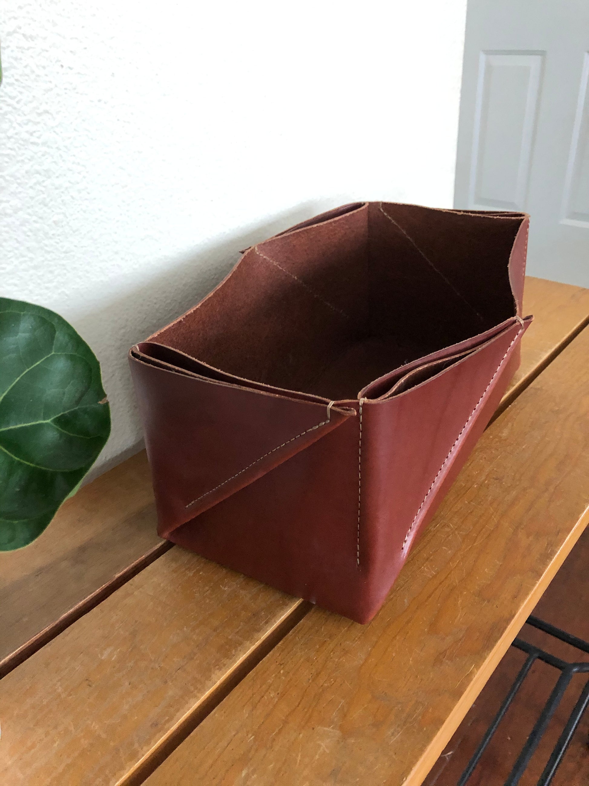 Organic shape of folded leather box decorates entryway table.