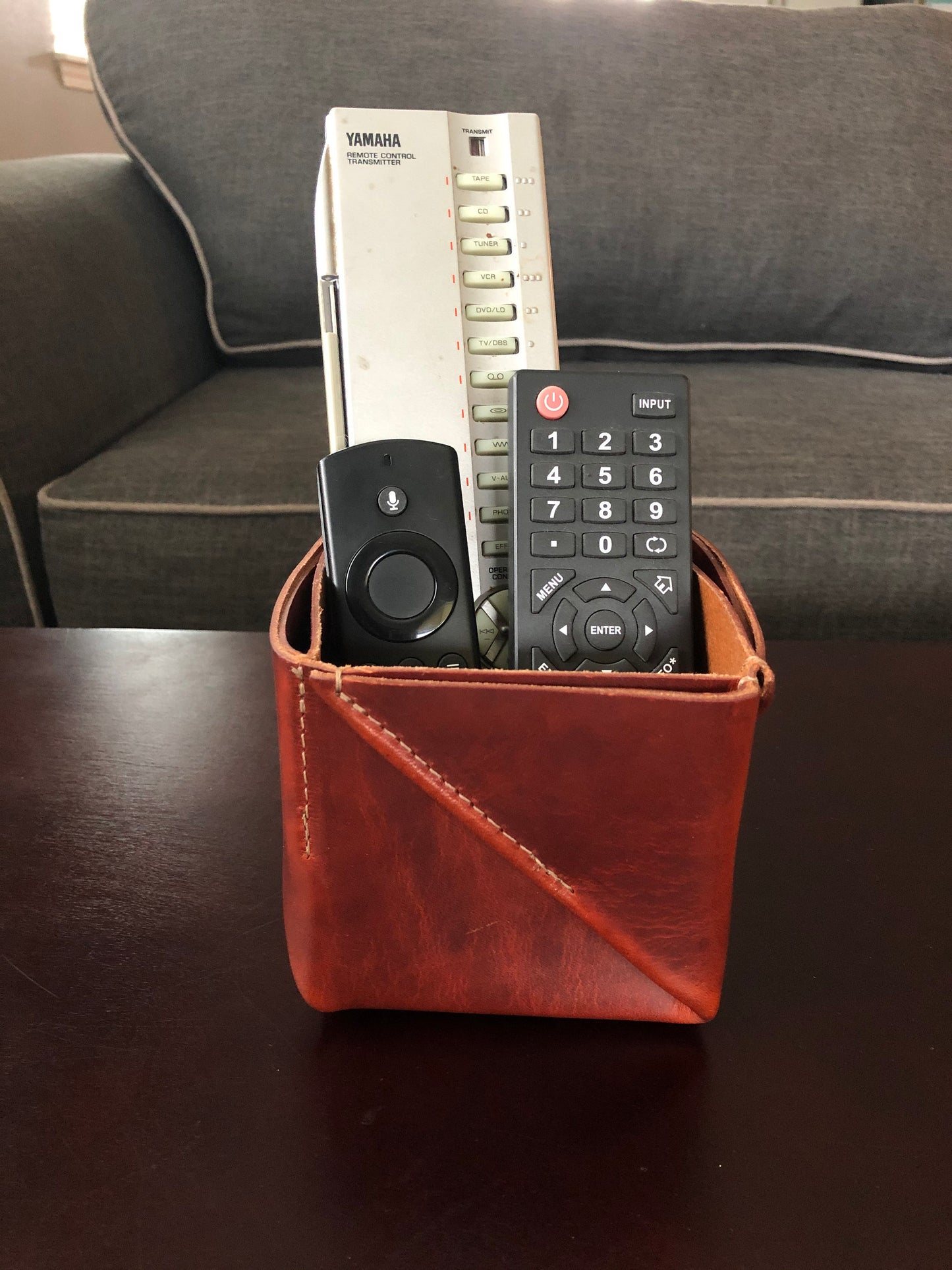 Brown folded leather box holds remotes in living room